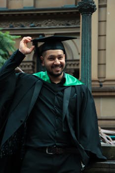 Excited university graduate in cap and gown celebrating his achievement outdoors in Sydney, Australia.