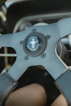 Detailed close-up of a classic Ford Mustang steering wheel, ideal for vintage car enthusiasts.